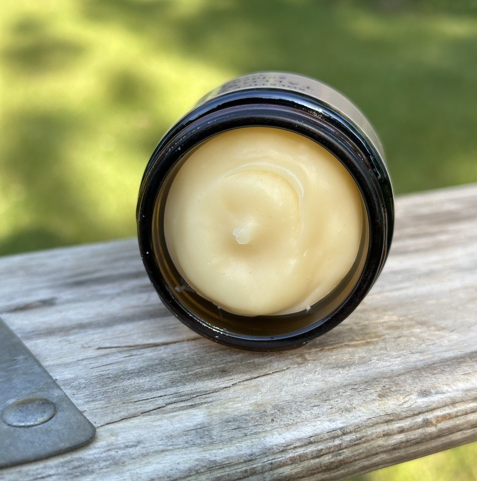 Tallow Balm Golden Hour product on display outside on a wooden bench.