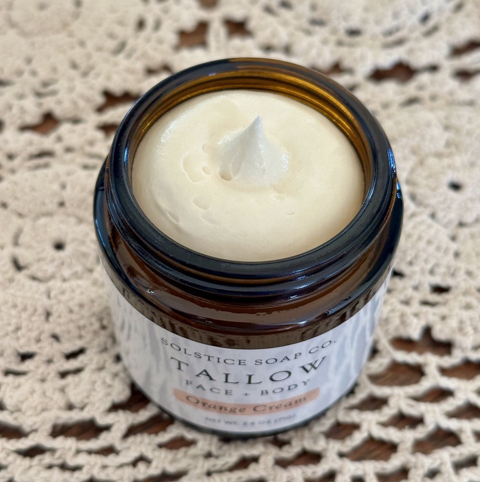 Whipped Tallow Orange Cream product on display on a doily.